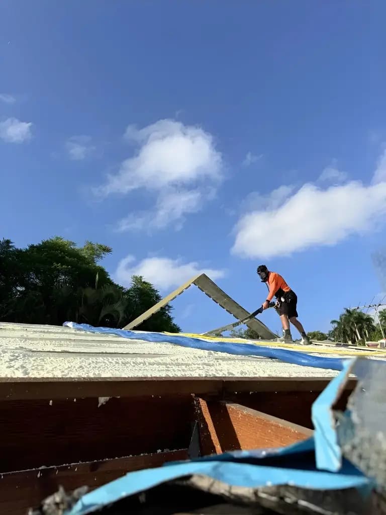 Installer spraying foam insulation on a roof
